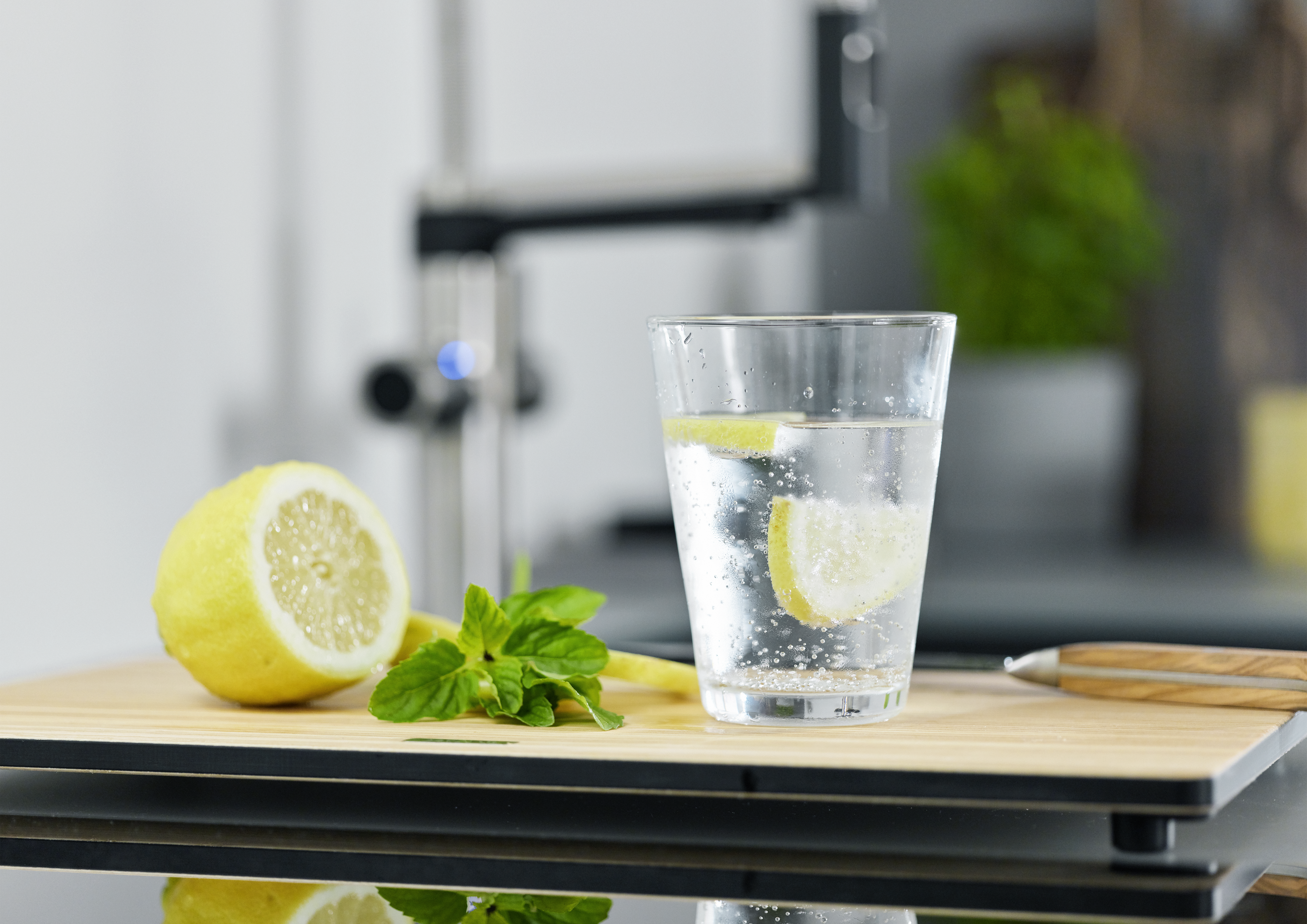 Glas Soda-Wasser mit Zitrone. Im Hintergrund Armatur BLANCO EVOL-S Pro Soda. 