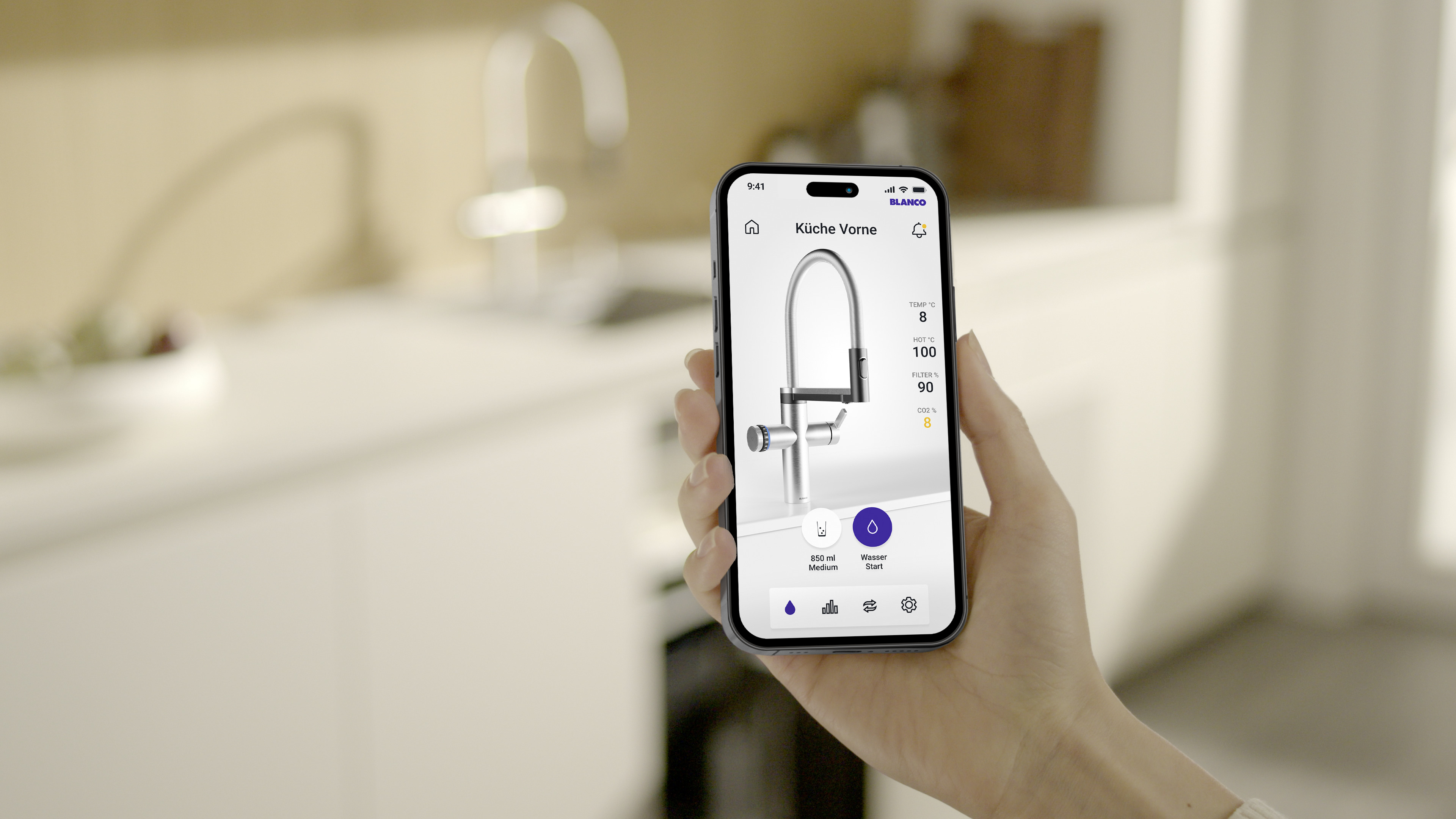 Eine Person hält ein Smartphone hoch, während im Hintergrund ein Küchenwasserhahn zu sehen ist.