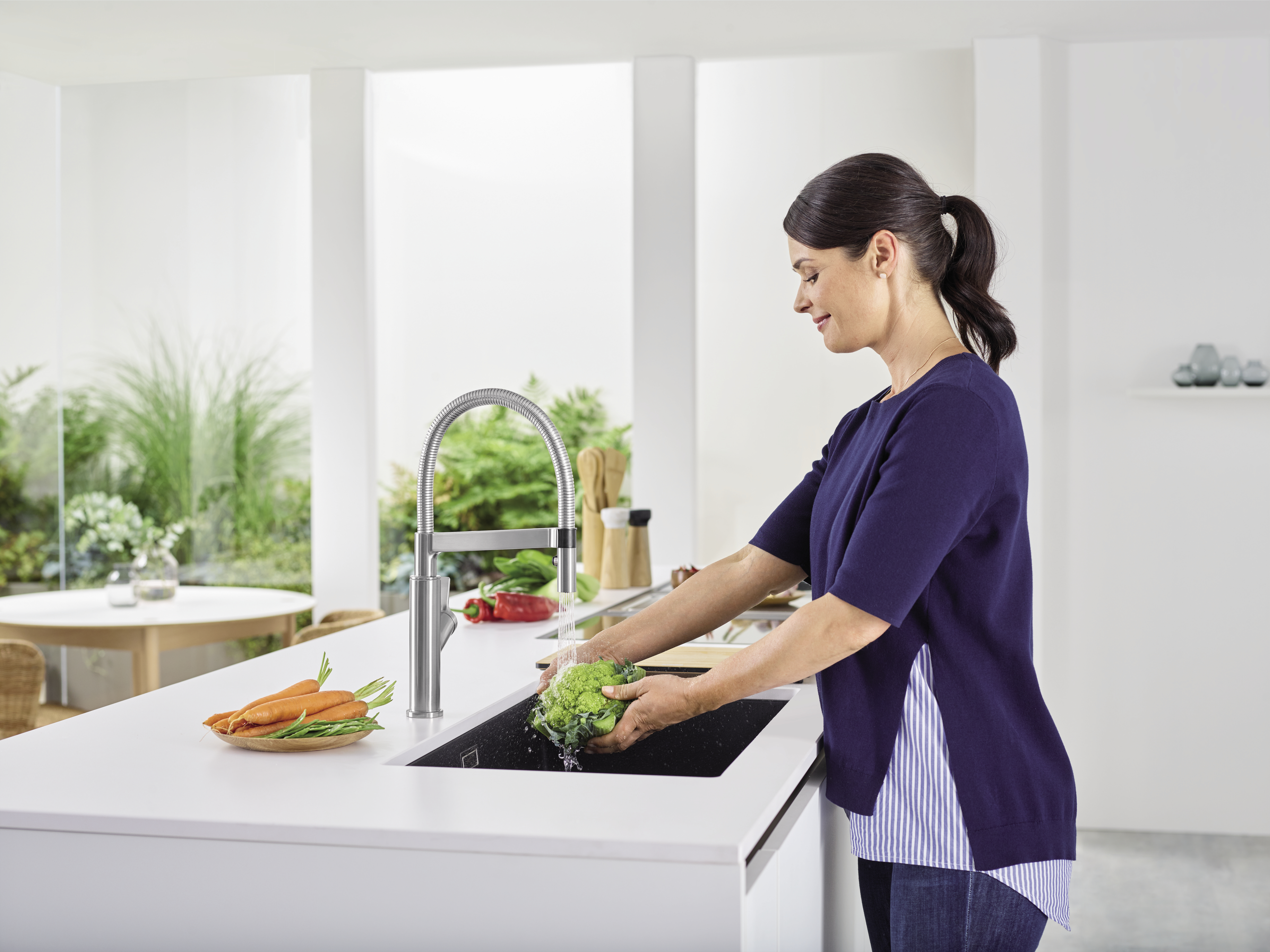 Frau wäscht Gemüse in einer BLANCO-Spüle
