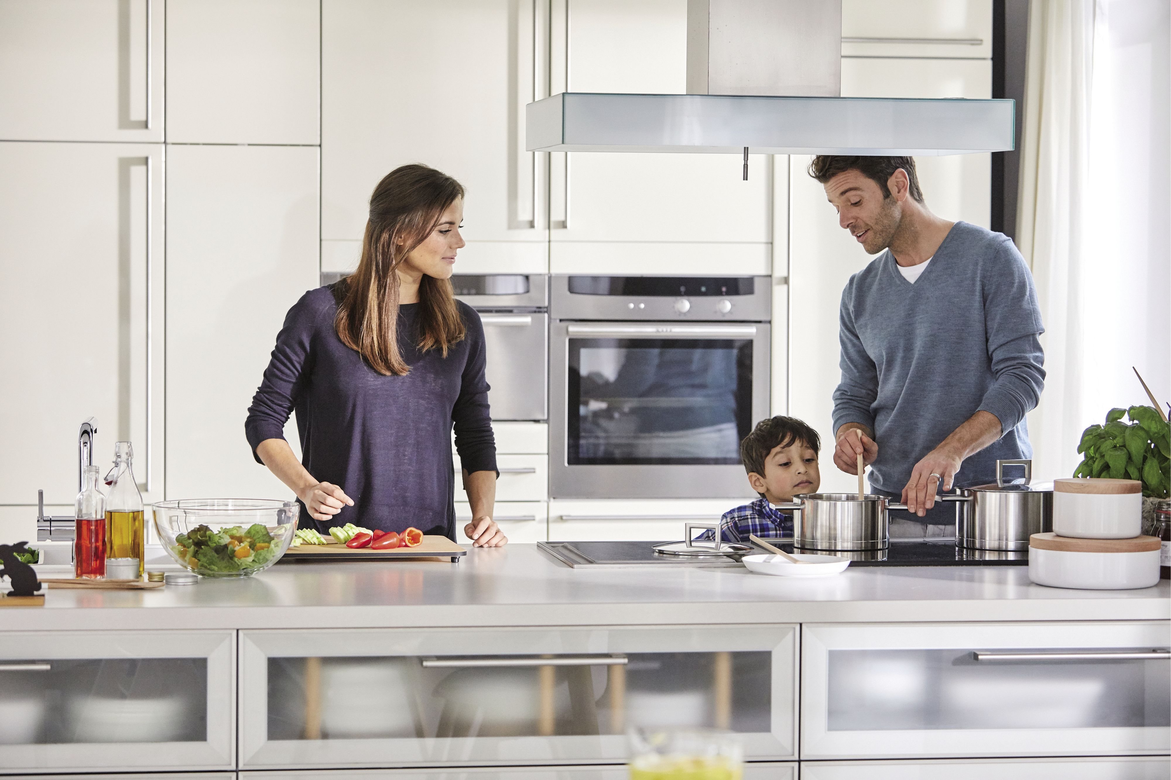 Eine Frau und ein kleiner Junge stehen zusammen in der Küche und kochen